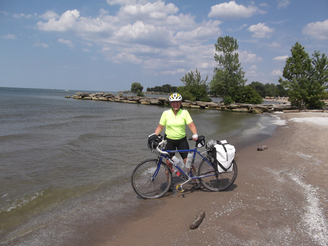 Mary and her Surly LHT tire dipping in Lake Erie at Edgewater Park in Cleveland Ohio after riding 350 milesThe Ohio to Erie Trail